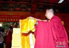 Oct. 18, 2016 -- The 11th Panchen Lama Bainqen Erdini Qoigyijabu concretes Hada to the scriptures written by Master Gajin Xiyarepei. (Photo by Li Lin)