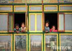 Dec. 12, 2016 -- Lying on the window sill, children put happy smiles on their faces. [Photo/Tibet.cn]