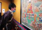 Dec. 26, 2016 -- A visitor looks at the displayed thangkas in Lhasa on Dec 23. [Photo by Palden Nyima/provided to chinadaily.com.cn]