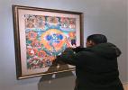 Jan. 10, 2017 -- A visitor takes a photo of a displayed Thangka painting at the National Art Museum of China, Beijing, Jan. 7, 2017. [Photo / China.org.cn]