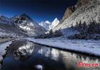 Jan. 16, 2017 -- Snowcapped peaks are reflected in water in Daocheng County, Garze Tibetan Autonomous Prefecture, Southwest China`s Sichuan Province. The county has three mountains sacred in Tibetan Buddhism. [Photo/Ecns.cn]