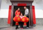Jan. 25, 2017 -- Gao Yiyue and her parents pose in front of Spring Festival couplets and lanterns at an agricultural experience park in Yichang, Central China`s Hubei province, on Jan 20, 2017. [Photo/VCG]