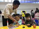 June 28,2017--Photo shows a worker of Tibet Museum of Natural and Science helping kindergarten kids to know about trilobita and processing its fossil during a lesson of archaeology. [China Tibet News/ Liu Fang]