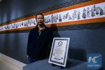 Nov. 13, 2017 -- Painter Huang Jialin and the record certificate. (Xinhua/Liu Dongjun)