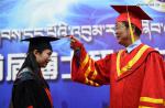 Nov. 13, 2017 -- President of Tibet University Ji Jianzhou turns the tassel for Zhang Hui during a graduation ceremony in Lhasa, southwest China`s Tibet Autonomous Region, Nov. 10, 2017. Four PhD candidates researching Tibetan history, language or medicine became the first group of holders of doctorates awarded by a Tibetan university. (Xinhua/Chogo)