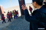 Nov. 24, 2017 -- Volunteer teacher Wu Tongyu waves goodbye to students after school at Bohai Primary School in Dagcanglhamo Township, Luqu County of Gannan Tibetan Autonomous Prefecture, northwest China`s Gansu Province, Nov. 17, 2017. Since 2015, 400 college students from universities within Gansu province have been dispatched to poor and ethnic regions as volunteer teachers in Gansu every year, which have contributed to the development of all-round education in these regions. (Xinhua/Liu Jinhai)