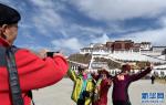 Mar. 20, 2018 -- Photo taken on March 14 shows tourists from Hebei Province are taking pictures at the Potala Palace Square, Lhasa, capital of southwest China`s Tibet Autonomous Region. In 2017, Tibet received 25.61 million tourists, generating 37.94 billion yuan in tourism revenue, a year-on-year increase of 10.6 percent and 14.7 percent respectively. [Photo/Xinhua]