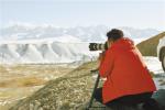 June 14,2018--A photographer is taking photos of snow mountain in Burang County. [China Tibet News/Wang Chun]