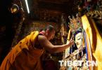 July 30,2018--Photo shows the 11th Panchen Lama spreads gold powder on the face of the statue of 12-year-old Sakyamuni Buddha.