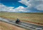 July 31,2018--Motorbike courier Gesang Cering performs a mail delivery task in Pumaqangtang Township of Nagarze County in Shannan, southwest China`s Tibet Autonomous Region, July 27, 2018. In Pumaqantang Township, the highest township in China, working as a postal service staff means delivering mails to addresses at altitudes of 5,000 meters and above. Gesang Cering, 29, is a motorbike courier with the local township branch of China Post. Twice a week, Gesang calls on the plateau villages under the township on a 160-km route, coping with extreme oxygen and temperature conditions. Despite its harsh geography, Tibet Autonomous Region has substantially improved the local postal service over the four decades since China`s reform and opening up. By the end of 2017, the postal road network had managed to cover all towns and counties within the autonomous region. (Xinhua/Li He)