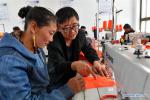 Aug.6,2018--Samkar Zhoima (L) learns sewing under technician Ma Ke`s guidance at a workshop in Gar County of Ngari Prefecture, southwest China`s Tibet Autonomous Region, July 31, 2018. In July, a clothes and carpet factory was set up to help raise income for the locals. [Photo/Xinhua]