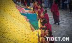 Aug.14,2018--Monks taking off the yellow silk cloth covering the Thangka painting.