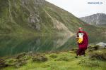 Aug.20,2018--A monk carries a blessed bottle during a worshipping ceremony at the sacred lake of Lhamo Lhatso in Gyaca County, Shannan Prefecture of southwest China`s Tibet Autonomous Region, Aug. 18, 2018. Bainqen Erdini Qoigyijabu, the 11th Panchen Lama, on Saturday held a worshipping ceremony at Lhamo Lhatso Lake. It is the first time for the Panchen Lama to pay a visit to Lhamo Lhatso, a sacred lake.(Xinhua/Dainzin Nyima Choktrul)