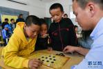 Sept. 6, 2018 -- Players from the Tibetan Chess Association of southwest China`s Tibet Autonomous Region are guiding children in the region`s welfare home to play Tibetan chess on September 1. After more than four years of popularization, many primary and secondary schools in the region`s capital Lhasa have opened Tibetan chess interest class, and the number of Tibetan chess enthusiasts at all ages in the region have reached more than 20,000. Tibetan chess ushers in the best development period in history.[Photo/Xinhua]