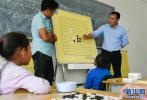 Sept. 6, 2018 -- Players from the Tibetan Chess Association of southwest China`s Tibet Autonomous Region are guiding children in the region`s welfare home to play Tibetan chess on September 1. After more than four years of popularization, many primary and secondary schools in the region`s capital Lhasa have opened Tibetan chess interest class, and the number of Tibetan chess enthusiasts at all ages in the region have reached more than 20,000. Tibetan chess ushers in the best development period in history.[Photo/Xinhua]
