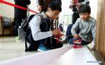 Dec. 3, 2018 -- A pupil from Shanghai adjusts a ladder-climbing robot during the 15th Shanghai Future Engineer Competition in Shanghai, east China, Dec. 1, 2018. More than 1,600 students from Shanghai and Xigaze of southwest China`s Tibet Autonomous Region took part in the competition, which opened here on Saturday. (Xinhua/Fang Zhe)