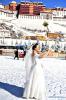 Dec. 21, 2018 -- A woman poses for wedding photos at the snow-covered Potala Palace square in Lhasa, capital of southwest China`s Tibet Autonomous Region, Dec. 19, 2018. Lhasa witnessed the first snow this winter on Tuesday. (Xinhua/Chogo)