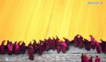 Feb. 18, 2019 -- Lamas of the Labrang Monastery unroll the huge thangka scroll painting bearing the image of the Buddha covered by a large yellow curtain during the annual `sunning of the Buddha` ceremony of Labrang Monastery in Xiahe County, northwest China`s Gansu Province, on Feb. 17, 2019. The annual `sunning of the Buddha` is one of the most important ceremonies at Labrang in Xiahe County, which is regarded as a top Tibetan Buddhism educational institution in China. The ceremony is held each year on the 13th day of the first lunar month. It also attracted crowds of tourists. Built in 1709, Labrang Monastery is one of the six great monasteries of the Gelug Sect of Tibetan Buddhism. (Xinhua/Chen Bin)