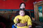 Feb. 28, 2019 -- A herdswoman takes care of her child in Garco Township of Shuanghu County, southwest China`s Tibet Autonomous Region, Jan. 31, 2019. Shuanghu County, located 5,000 meters above sea level in southwest China`s Tibet Autonomous Region, suffers from strong winds 200 days a year. With a year-round temperature averaging minus five degrees Celsius, Shuanghu is home to the world`s third largest glacier, the Purog Kangri. Occasionally, the temperature here drops to minus 40 degrees Celsius. The county, about 120,000 square kilometers in area, lies in the middle of the Qiangtang National Nature Reserve. There are 135 conservation staff members working in Shuanghu`s 15 wildlife management and conservation stations to improve protection of wild animals. In 2018, the county government suspended construction of tourism-related support facilities around the Purog Kangri glacier to better protect the environment. Shuanghu now has about 20,000 wild yaks and 200,000 Tibetan antelopes, plus more than 20 rare species such as the snow leopard and brown bear. (Xinhua/Purbu Zhaxi)