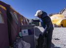 May 14, 2019 -- The mountain guide Sonam Tsering throws the garbage into the trash can at the base camp of the northern face of Mount Qomolangma in southwest China`s Tibet Autonomous Region, April 26, 2019. Every year, for a few weeks, hundreds of climbers and supporting personnel come to the base camp of the northern face of Mount Qomolangma, trying to reach the summit of the tallest and most famous mountain in the world. Before starting climbing, they need to hike several times between elevations from 5,000 meters to 7,000 meters, giving their bodies some time to adapt. When this process is over, it`s all up to the weather. The base camp is a popular place to wait for the window. Among the six camps on the northern face, the base camp at an altitude of 5,200 meters is the furthest cars can reach and therefor the most equipped. Besides food and accommodation, climbers can also enjoy tea and massage. They can also play football on perhaps the highest field. There`s even a simple gym in the camp. Environmental protection is a priority here. Garbage sacks are given to each climbing team. Special containers are put in every camp to collect trash and sewage. The collected trash must be treated 100 kilometers away, and the only road is a zigzagging track. It is not trucks, but yaks that are generally used to make the journey. Actually yaks are vital on the mountain. Beyond the base camp, yak is the only reliable transport. (Xinhua/Sun Fei)