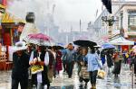 July 9, 2019 -- People walk in rain on the Porgor Street in Lhasa, southwest China`s Tibet Autonomous Region, July 3, 2019. (Xinhua/Zhang Rufeng)