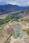 Aug.22, 2019 -- Aerial photo taken on Aug. 8, 2019 shows the Sijijixiang Village of Caina Township in Quxu County, southwest China`s Tibet Autonomous Region. Sijijixiang is a relocation village in a valley of Caina Township. It features Tibetan-style houses with four colors indicating the four seasons. On Dec. 15, 2016, over 260 impoverished households settle into their new home here from poverty-stricken areas in Quxu, along with another 98 households who used to live above 4500 meters on the plateau. Thanks to the improved infrastructure, the village launched a series of projects to help villagers out of poverty and live a well-off life, including running seedling planting base, medical herbs base and cow farm. (Xinhua/Purbu Zhaxi)