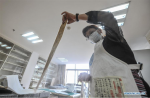 Sept.17, 2019 -- A staff member cleans an ancient document at the ancient documents protection center of Tibet in Lhasa, southwest China`s Tibet Autonomous Region, Sept. 12, 2019. Since 2010, over 18,000 ancient documents in Tibet have been registered, with 291 ancient books being listed as national rare antique books. More than 3,000 pages of ancient documents from Paingar and Mangra monasteries have been restored. (Xinhua/Jigme Dorje)