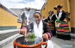 Sept.23, 2019 -- Villager Dainzin Quzhen (front) holds a traditional rite in front of her new house in Lhozhag Town of Lhozhag County, Shannan City, southwest China`s Tibet Autonomous Region, Sept. 21, 2019. A total of 88 villagers from 28 households moved to their new two-story dwellings to improve housing conditions. (Xinhua/Jigme Dorje)