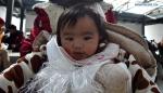 Dec.25,2019 -- Photo taken on Dec. 23, 2019, shows a 7-month-old baby from Shuanghu County, Nagchu City, southwest China`s Tibet Autonomous Region, on the migration trip. A total of 2,900 residents from three villages of Shuanghu County, have recently left their hometown with an average altitude of 5,000 meters above sea level and travelled nearly 1,000 kilometers to resettle in Konggar County, which, at a relatively low altitude, is located to the south bank of the Yarlung Zangbo River in southern Tibet. (Xinhua/Chogo)