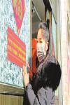 Feb.11,2020 -- Metog Lhatse, a cadre of the Publicity Department of Qonggyai County`s Party committee in Shannan City, southwest China`s Tibet Autonomous Region, is pasting publicity slogan of epidemic prevention on the door of a vegetable shop in the county seat. [Photo/Tsering, Losang]
