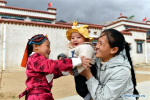 April 8,2020 -- Shizhen plays with her daughter Gesang Quda and son Gama Quying at the Rongma relocation settlement in Gurum Township of Lhasa, capital of southwest China`s Tibet Autonomous Region, April 1, 2020. In 2018, more than 1,000 shepherds moved from Qiangtang grassland with an average altitude of about 5,000 meters in Rongma Township of Nagqu City to the Rongma relocation settlement, 30 kilometers west of Lhasa, thanks to the local policy on poverty alleviation. This measure also makes room for the living of wild animals at the Qiangtang National Nature Reserve. With the help of local government, the relocated people have developed the cultivation industry of yaks and sheep and other special pasture-style projects, thus increasing their incomes. (Xinhua/Zhan Yan)