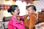 April 8,2020 -- Baimaluozong holds her child at home at the Rongma relocation settlement in Gurum Township of Lhasa, capital of southwest China`s Tibet Autonomous Region, April 1, 2020. In 2018, more than 1,000 shepherds moved from Qiangtang grassland with an average altitude of about 5,000 meters in Rongma Township of Nagqu City to the Rongma relocation settlement, 30 kilometers west of Lhasa, thanks to the local policy on poverty alleviation. This measure also makes room for the living of wild animals at the Qiangtang National Nature Reserve. With the help of local government, the relocated people have developed the cultivation industry of yaks and sheep and other special pasture-style projects, thus increasing their incomes. (Xinhua/Zhan Yan)