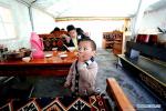 April 21,2020 -- Puba Doje, Gedor`s son, is seen in his family`s teahouse at a relocation site in Gangdoi Town of Gonggar County, southwest China`s Tibet Autonomous Region, April 15, 2020. Gedor, 34, used to live in a remote pastoral area in Amdo County in northern Tibet with his family. Restricted by the living conditions, they earned a living by pasture and the low income of their small grocery store. In late 2019, with the support of local authorities, 4,058 residents in Amdo and Co Nyi, two counties at a high altitude of over 4,500 meters, were relocated. Gedor and his family moved to a relocation site in Gangdoi Town of Gonggar County. The site has easy access to roads and various facilities including market, hospital and school. The convenience of new life has encouraged Gedor and his wife Rolpai to open a Tibetan butter teahouse for neighboring residents to spend leisure time. Now, Gedor and his family live a better life as their teahouse has been a popular spot with satisfactory income, and with the allowance from local authorities. (Xinhua/Zhan Yan)