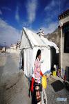 April 21,2020 -- Rolpai, Gedor`s wife, works outside her teahouse at a relocation site in Gangdoi Town of Gonggar County, southwest China`s Tibet Autonomous Region, April 16, 2020. Gedor, 34, used to live in a remote pastoral area in Amdo County in northern Tibet with his family. Restricted by the living conditions, they earned a living by pasture and the low income of their small grocery store. In late 2019, with the support of local authorities, 4,058 residents in Amdo and Co Nyi, two counties at a high altitude of over 4,500 meters, were relocated. Gedor and his family moved to a relocation site in Gangdoi Town of Gonggar County. The site has easy access to roads and various facilities including market, hospital and school. The convenience of new life has encouraged Gedor and his wife Rolpai to open a Tibetan butter teahouse for neighboring residents to spend leisure time. Now, Gedor and his family live a better life as their teahouse has been a popular spot with satisfactory income, and with the allowance from local authorities. (Xinhua/Zhan Yan)