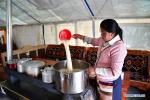 April 21,2020 -- Rolpai, Gedor`s wife, prepares food for customers in their teahouse at a relocation site in Gangdoi Town of Gonggar County, southwest China`s Tibet Autonomous Region, April 15, 2020. Gedor, 34, used to live in a remote pastoral area in Amdo County in northern Tibet with his family. Restricted by the living conditions, they earned a living by pasture and the low income of their small grocery store. In late 2019, with the support of local authorities, 4,058 residents in Amdo and Co Nyi, two counties at a high altitude of over 4,500 meters, were relocated. Gedor and his family moved to a relocation site in Gangdoi Town of Gonggar County. The site has easy access to roads and various facilities including market, hospital and school. The convenience of new life has encouraged Gedor and his wife Rolpai to open a Tibetan butter teahouse for neighboring residents to spend leisure time. Now, Gedor and his family live a better life as their teahouse has been a popular spot with satisfactory income, and with the allowance from local authorities. (Xinhua/Zhan Yan)