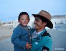 April 21,2020 -- Gedor holds his son Zhaxi Nyima at a relocation site in Gangdoi Town of Gonggar County, southwest China`s Tibet Autonomous Region, April 15, 2020. Gedor, 34, used to live in a remote pastoral area in Amdo County in northern Tibet with his family. Restricted by the living conditions, they earned a living by pasture and the low income of their small grocery store. In late 2019, with the support of local authorities, 4,058 residents in Amdo and Co Nyi, two counties at a high altitude of over 4,500 meters, were relocated. Gedor and his family moved to a relocation site in Gangdoi Town of Gonggar County. The site has easy access to roads and various facilities including market, hospital and school. The convenience of new life has encouraged Gedor and his wife Rolpai to open a Tibetan butter teahouse for neighboring residents to spend leisure time. Now, Gedor and his family live a better life as their teahouse has been a popular spot with satisfactory income, and with the allowance from local authorities. (Xinhua/Zhan Yan)