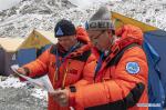 May 8,2020 -- Xue Qiangqiang (L) and his teammate view a map at the base camp of Mount Qomolangma in southwest China`s Tibet Autonomous Region, May 2, 2020. It is the first time for Xue Qiangqiang, 37, to ascend Mount Qomolangma, the world`s highest peak. He is a member of a Chinese team to remeasure the mountain`s height in May. (Xinhua/Jigme Dorje)