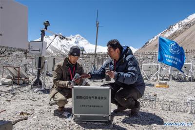 Staff members of region’s meteorological bureau work at automatic meteorological station of Mount Qomolangma base camp