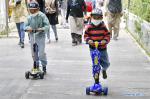 June 24,2020 -- Two boys play with kick scooters at Longwangtan Park near the Potala Palace in Lhasa, southwest China`s Tibet Autonomous Region, June 21, 2020. (Xinhua/Zhang Rufeng)