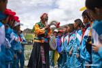 July 21,2020 -- Nyima interacts with pupils at a primary school in Qonggyai County in Shannan, southwest China`s Tibet Autonomous Region, July 2, 2020. Jiuhe Zhuo dance, originated in Qonggyai County of Shannan, has a history of more than 1,300 years. It has been a favorite dancing form for local people in Shannan to pray for good luck since ancient times and was dubbed waist drum dance in Tibet. Nyima, an inheritor of Jiuhe Zhuo dance, which is a national intangible cultural heritage, began to learn the dance from his father at the age of nine and has been dedicated to Zhuo dance performance for over 60 years. His performance once won a national award for folk arts. After decades of study of the dance, Nyima has formed his unique style. During the performance, he plays the role of leading dancer and controls the movements and rhythm of the dance. Nyima has trained dozens of apprentices and formed a Zhuo dance performing team in Jiuhe Village. Now, young dancers of the team often perform in different places. The Zhuo dance has become an important approach to reducing poverty for local villagers. (Xinhua/Purbu Zhaxi)