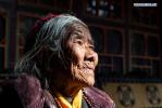 March 19,2021 -- Drungtok poses for a photo at home in Xigaze, southwest China`s Tibet Autonomous Region, Jan. 15, 2021. Drungtok, a former serf of Bailug manor in old Tibet, has seen her life totally changed from before. In the old days, Drungtok and her ancestors worked as serfs at the Bailug manor, making barley wine for the manor owner to offset the duty. She offered their labor all year long but never drunk the wine herself. Nowadays, she lives in a Tibetan yard with her grandchildren, drinking barley wine and enjoying time with families. (Xinhua/Purbu Zhaxi)