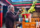 March 19,2021 -- Drungtok waters plants at home in Xigaze, southwest China`s Tibet Autonomous Region, Jan. 15, 2021. Drungtok, a former serf of Bailug manor in old Tibet, has seen her life totally changed from before. In the old days, Drungtok and her ancestors worked as serfs at the Bailug manor, making barley wine for the manor owner to offset the duty. She offered their labor all year long but never drunk the wine herself. Nowadays, she lives in a Tibetan yard with her grandchildren, drinking barley wine and enjoying time with families. (Xinhua/Jigme Dorje)