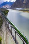 June 28,2021 -- Aerial photo taken on June 16, 2021 shows a Fuxing bullet train running on the Lhasa-Nyingchi railway over the Yarlung Zangbo River during a trial operation in southwest China`s Tibet Autonomous Region. (Xinhua/Purbu Zhaxi)