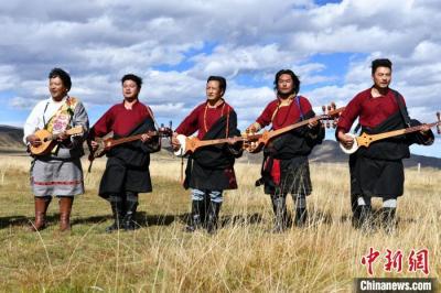 Artists play Tibetan instruments on prairie in Sichuan