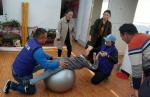 Cao Longjun (left) and Ma Xiaowei (right), two doctors from the Tianjin University of Sport, train a child who has spastic cerebral palsy. [Photo provided to chinadaily.com.cn]