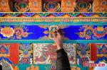 A craftsperson from a handcraft cooperative decorates a house in traditional Tibetan style in Lhasa, southwest China`s Tibet Autonomous Region, Dec. 28, 2021. (Photo/China News Service)