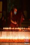 A monk lights butter lamps in the Sera monastery in Lhasa, China`s Tibet Autonomous Region, Dec 29, 2021. (Photo/China News Service)