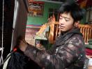 A young Tibetan villager works on of a Tibetan carpet in the weaving shop in Zangkha village. [Photo by Palden Nyima/chinadaily.com.cn]
