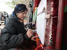 Tsanchung, a staff member at the weaving handicrafts workshop, crafts a Tibetan carpet in Zangkha village. [Photo by Palden Nyima/chinadaily.com.cn]