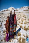 Tenzin Drolma (C) stands with her mother (R) and a neighbor girl while herding cattle in Gyaga Village of Damxung County, southwest China`s Tibet Autonomous Region, Jan. 18, 2022. 